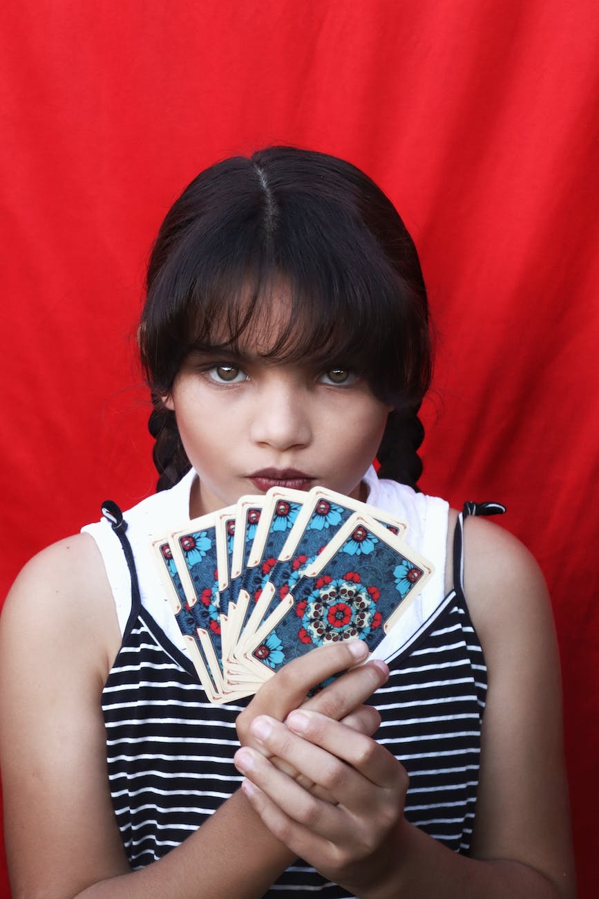 girl with a fringe holding cards