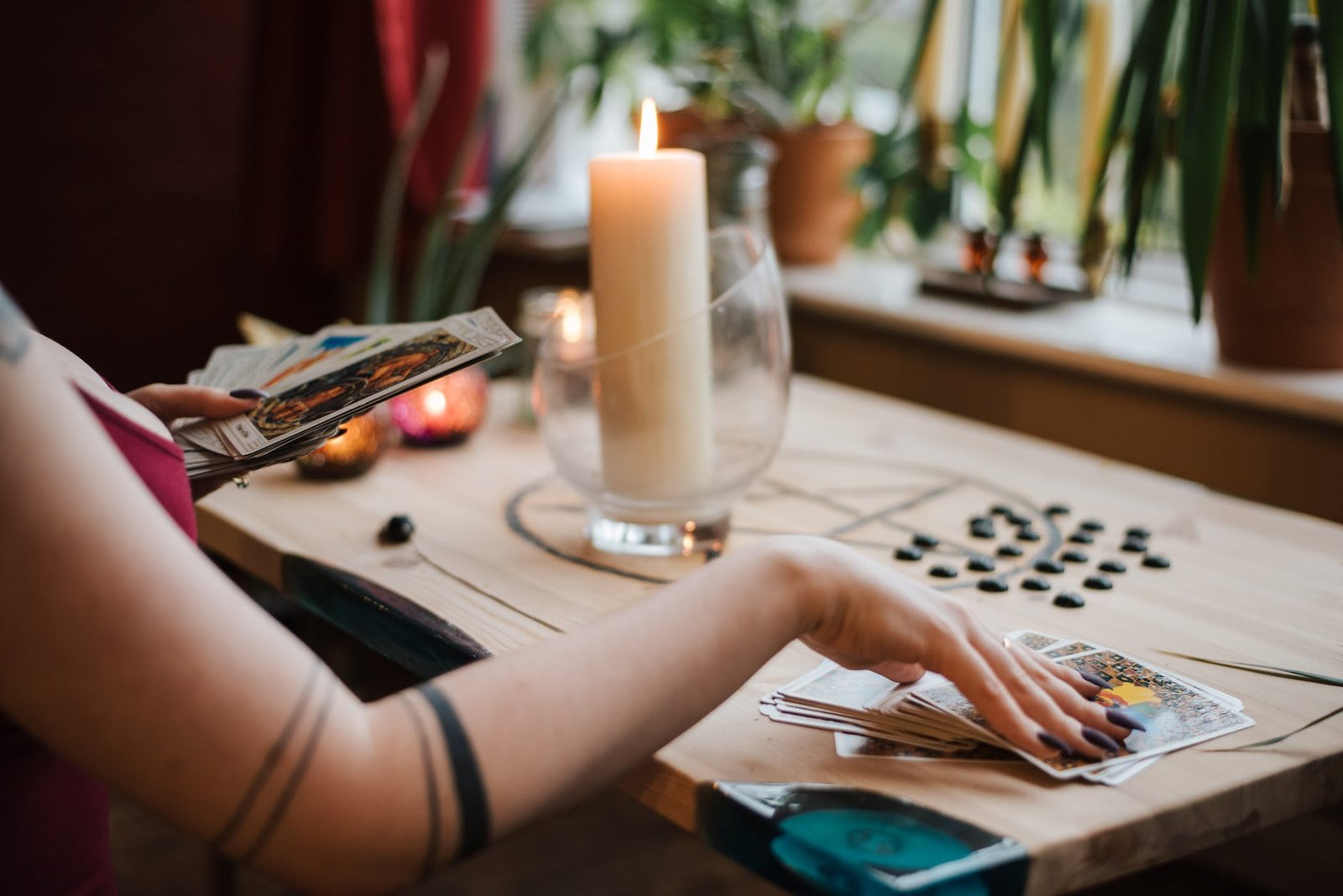 anonymous soothsayer reading tarot cards during divination process in house