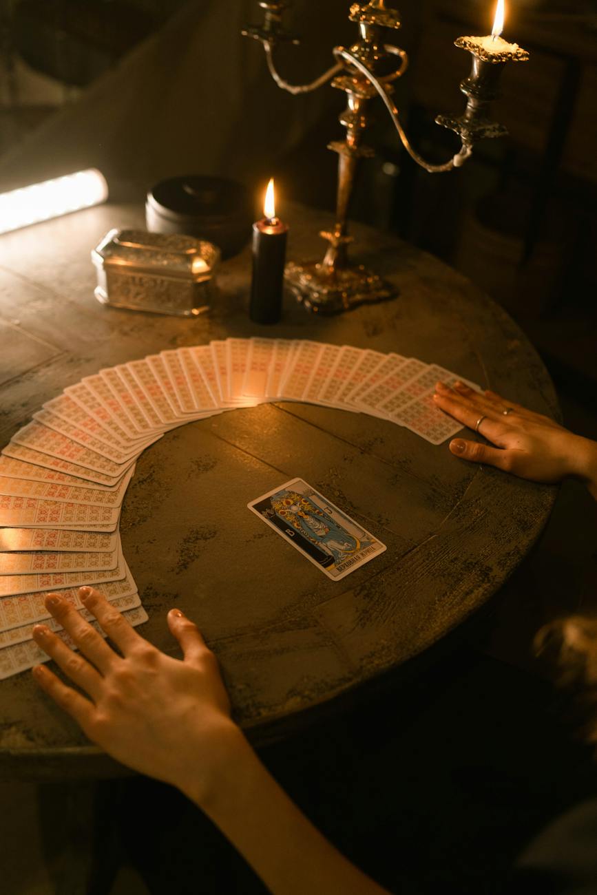 hands touching the tarot cards on the table