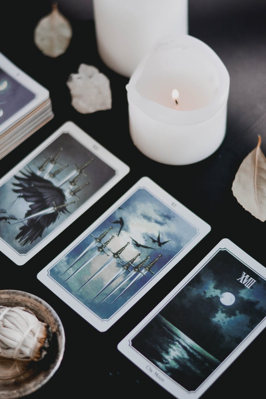 tarot cards and lighted candle on black surface