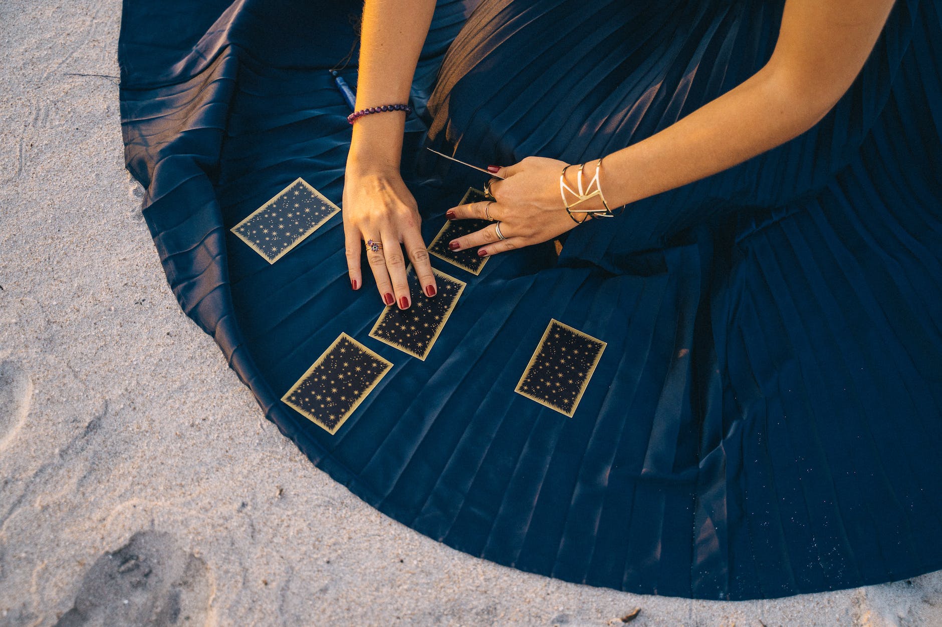 woman in blue skirt holding tarot cards