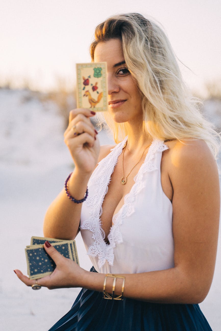 woman with blonde hair showing a tarot card