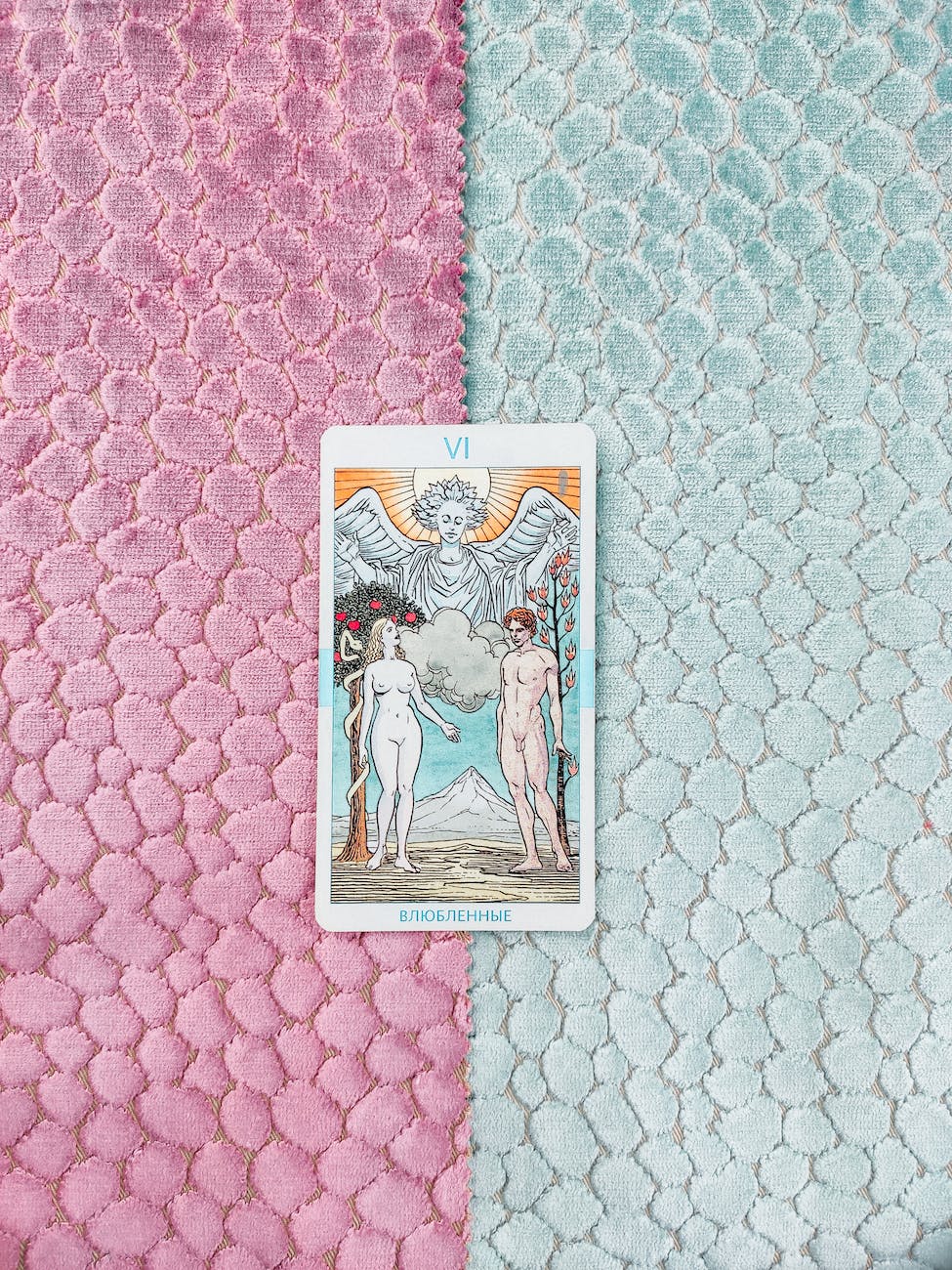 a tarot card om blue and pink surface